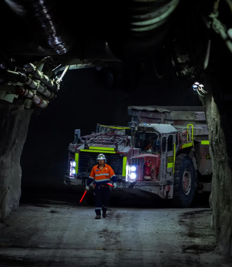 Underground mine haulage drift with a worker and a vehicle