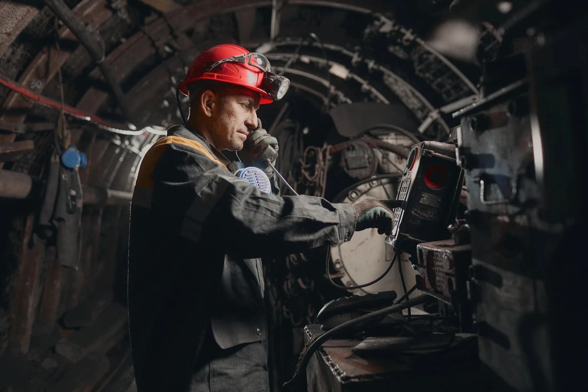 Miner at a control panel in an underground coal mine